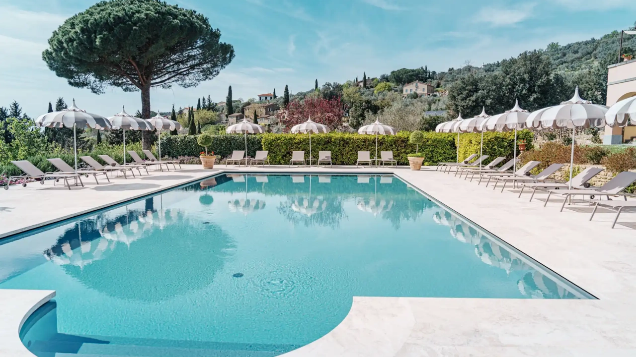 Il Falconiere Cortona — outdoor pool with Tuscan hillside views at the Relais & Châteaux